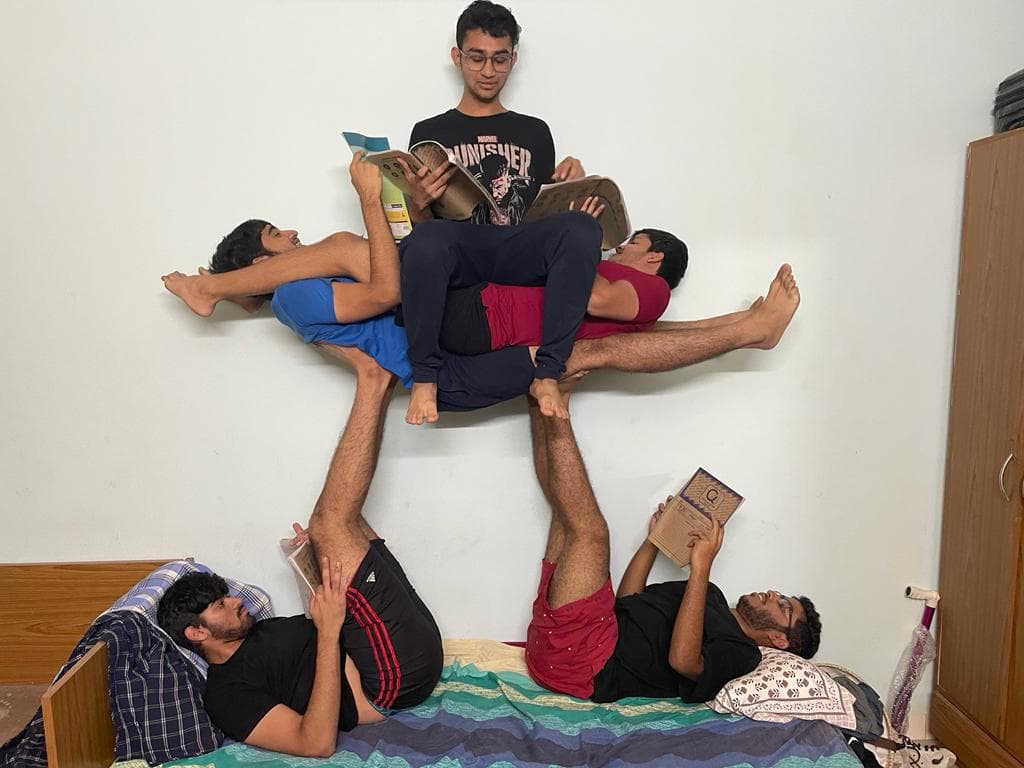 Nathan and four friends stacked into a human tower, all reading books